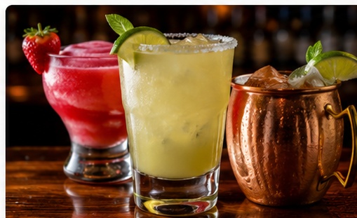 Frozen strawberry daiquiri, margarita, and a Moscow mule on a bar