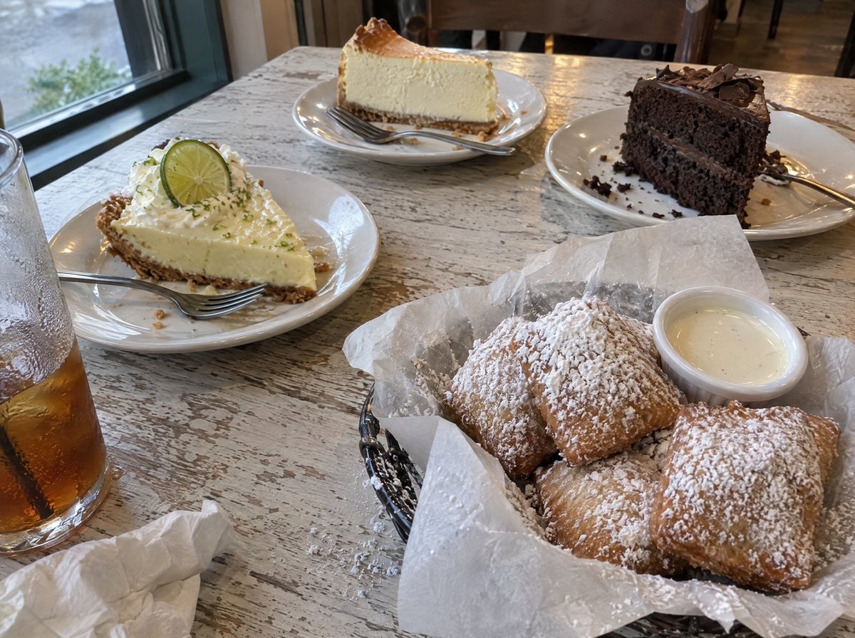 Cheesecake, key lime pie, chocolate cake and a basket of powdered-sugar biscuit beignets